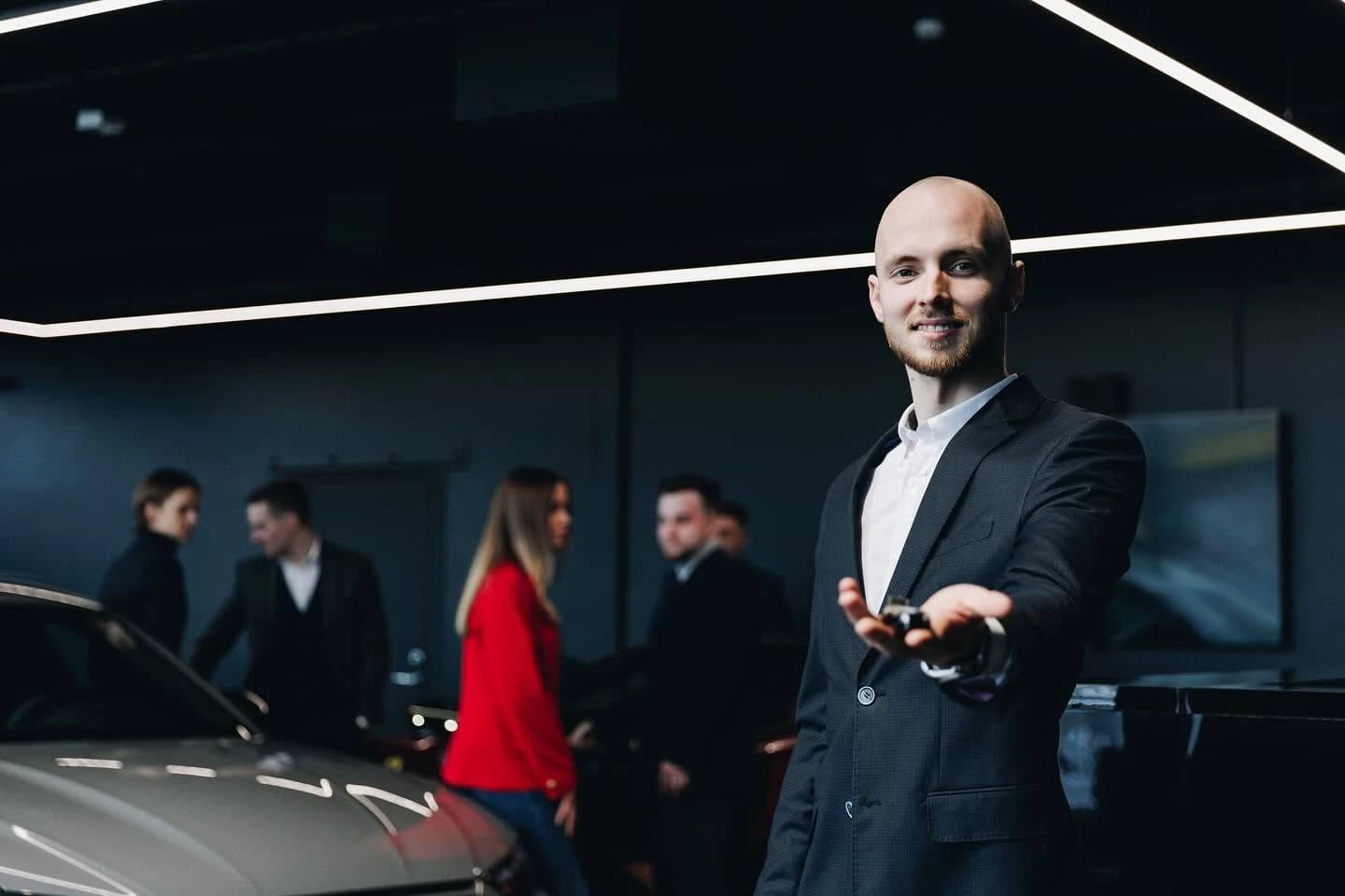 A Ferati consultant handing over a car key in the showroom